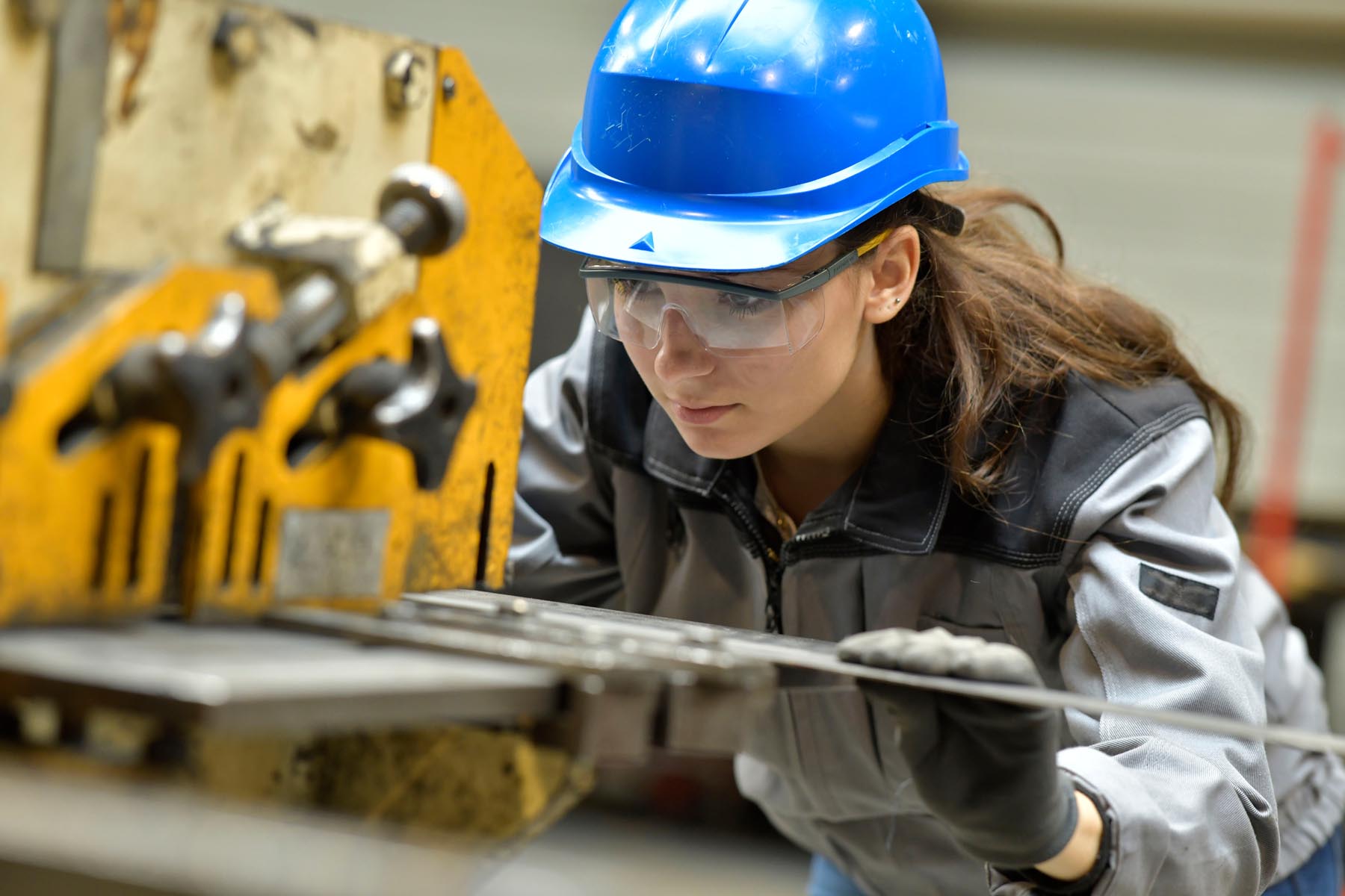 Jeune apprenti utilisant une machine d'aciérie